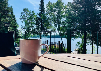 coffee cup on an table outside facing a lake